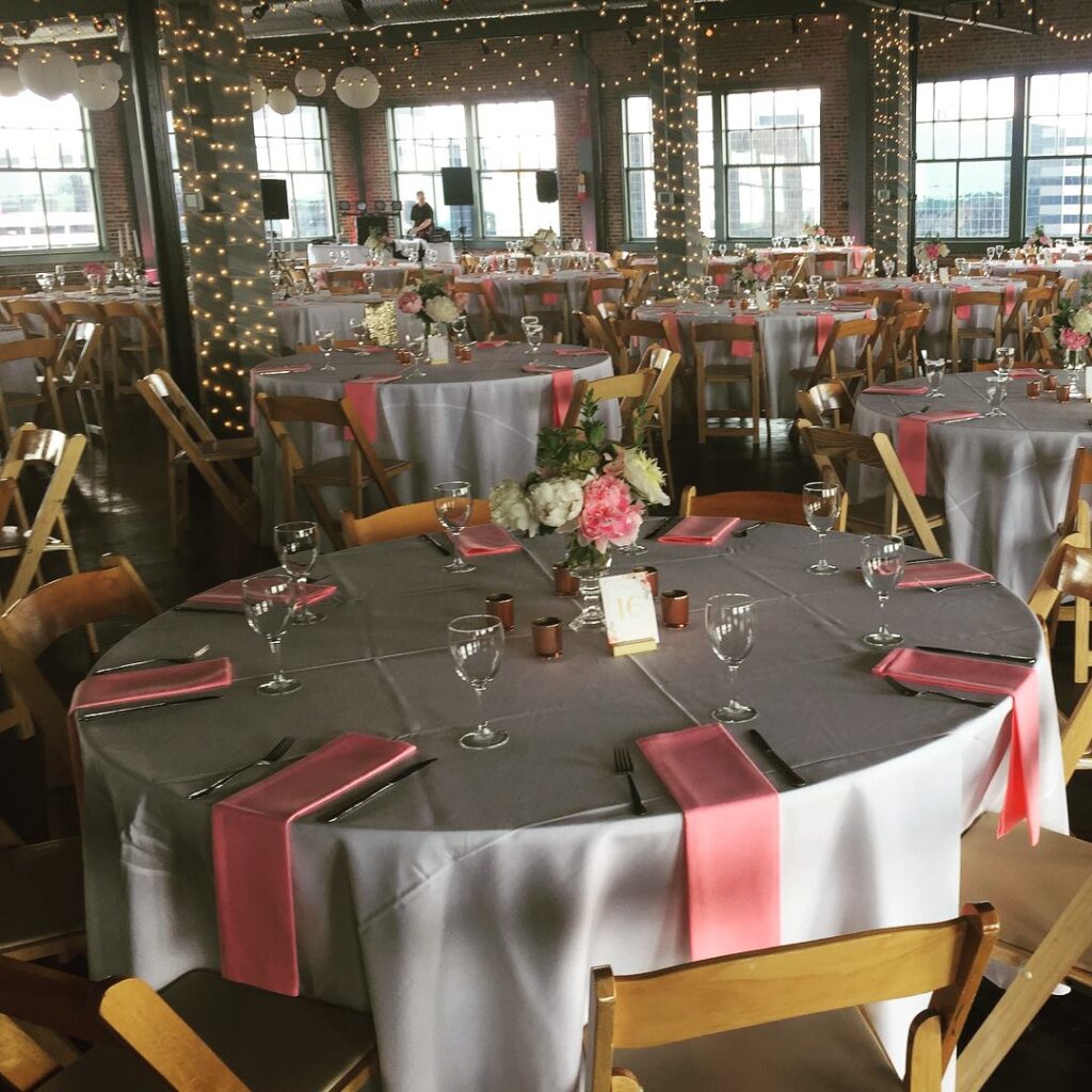 A spacious wedding venue with elegantly arranged tables and chairs